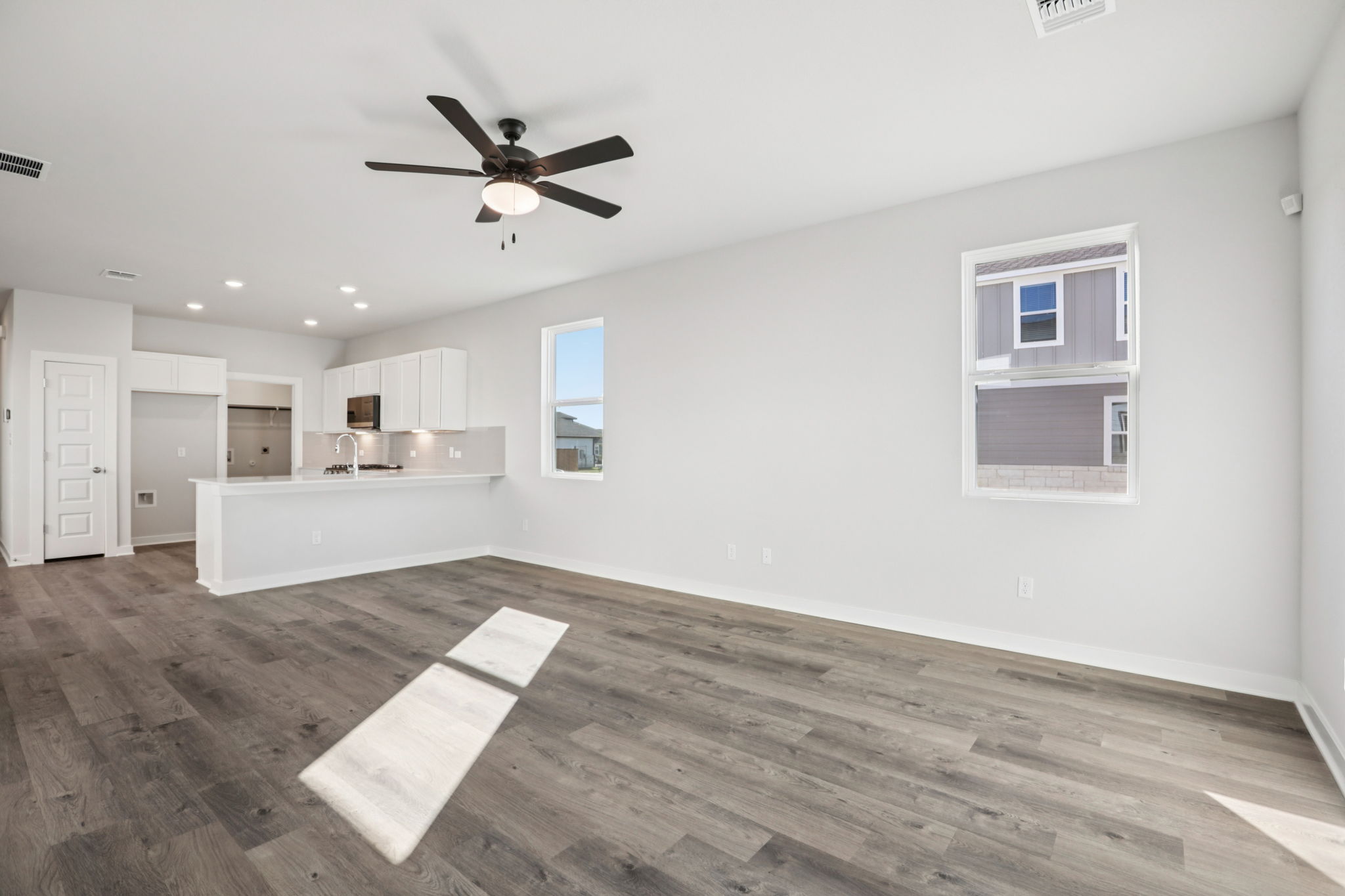 A room with a wood floor and a ceiling fan.