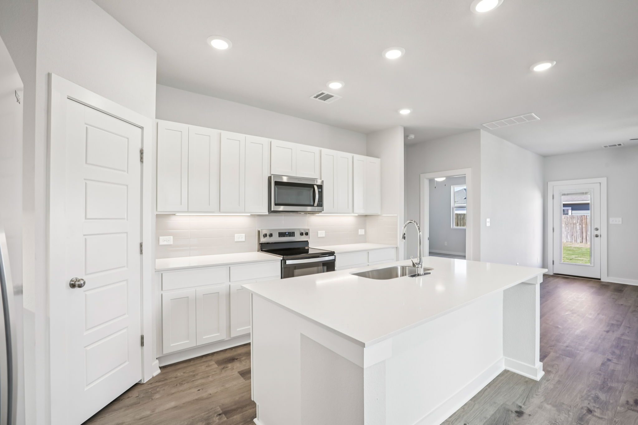 A kitchen with white cabinets.