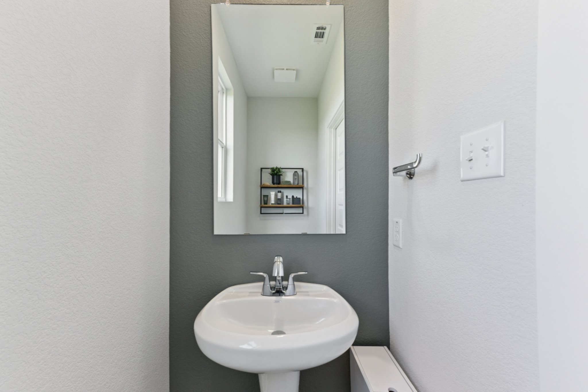A bathroom with a mirror and sink.