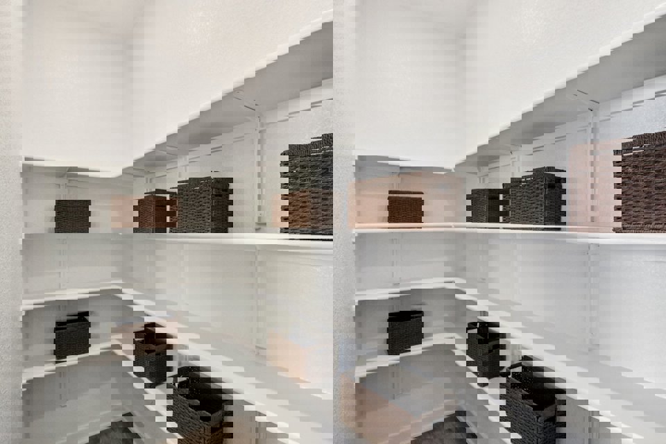 A white shelf with baskets on it.