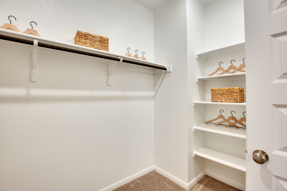 A white shelving unit with a basket and a basket on it.