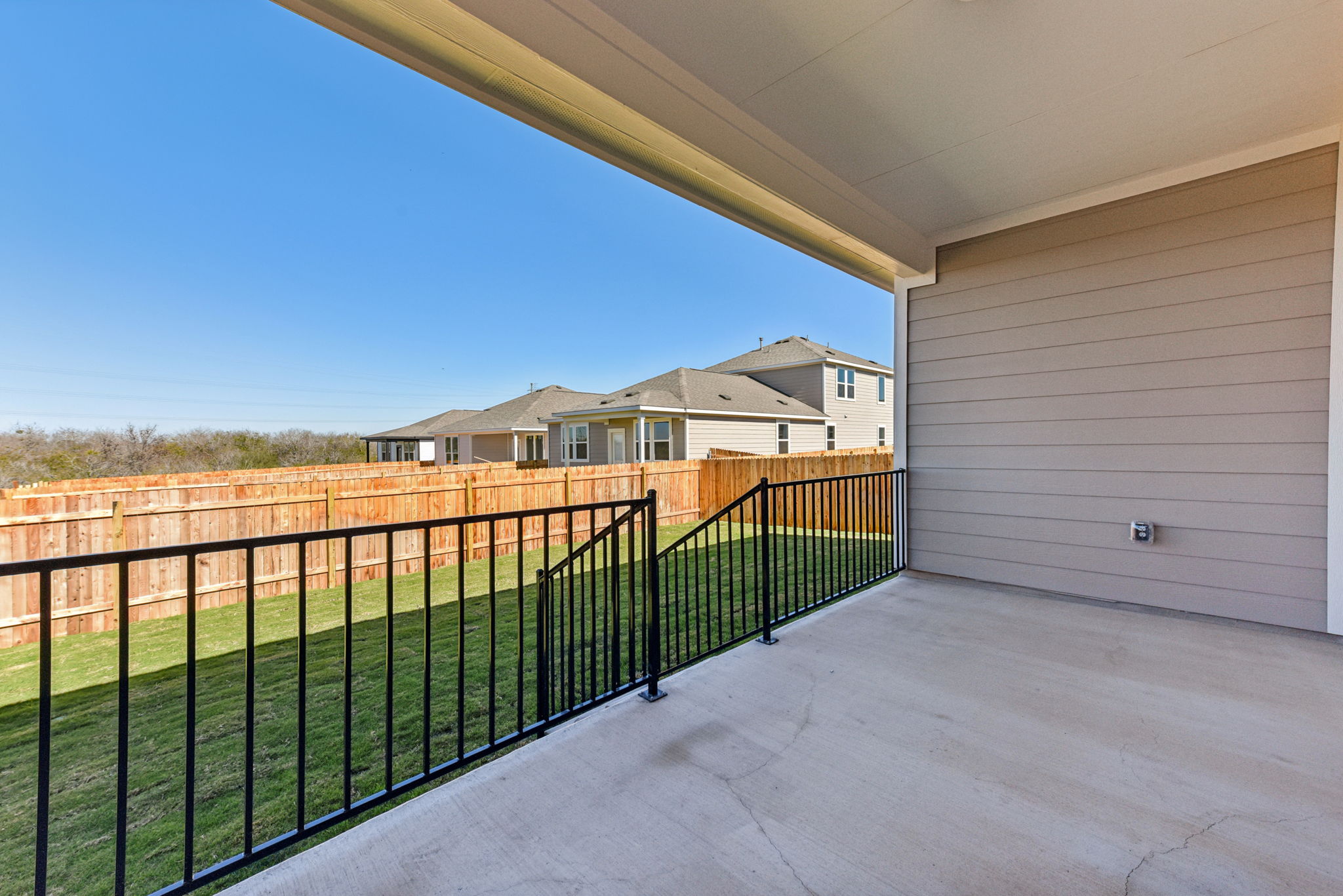 A house with a fence and a building in the background.