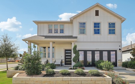 A white house with a green lawn.
