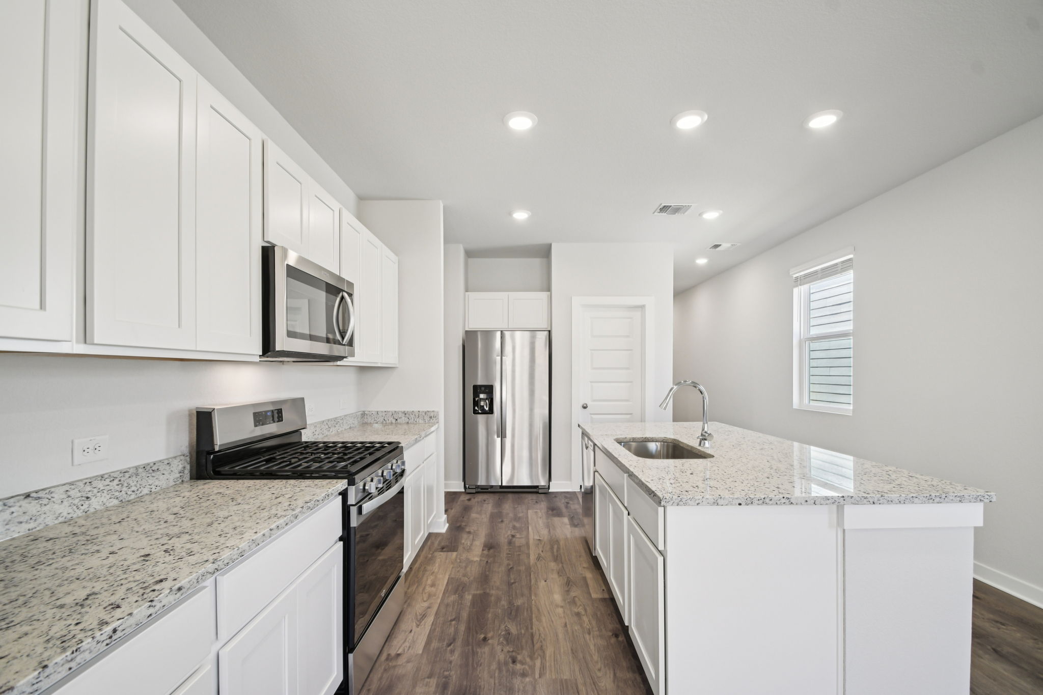 A kitchen with white cabinets.