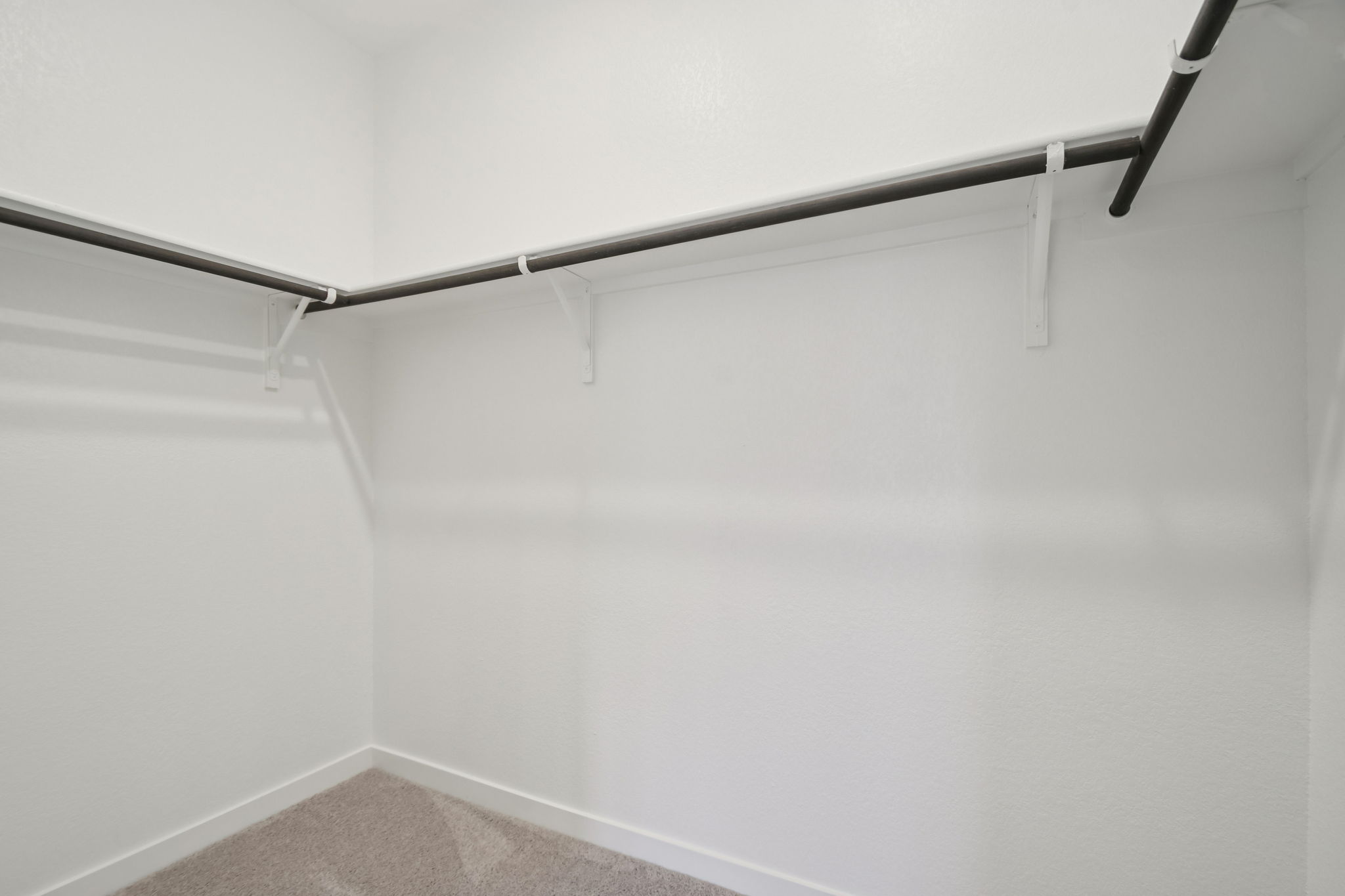 A white wall with a metal bar.