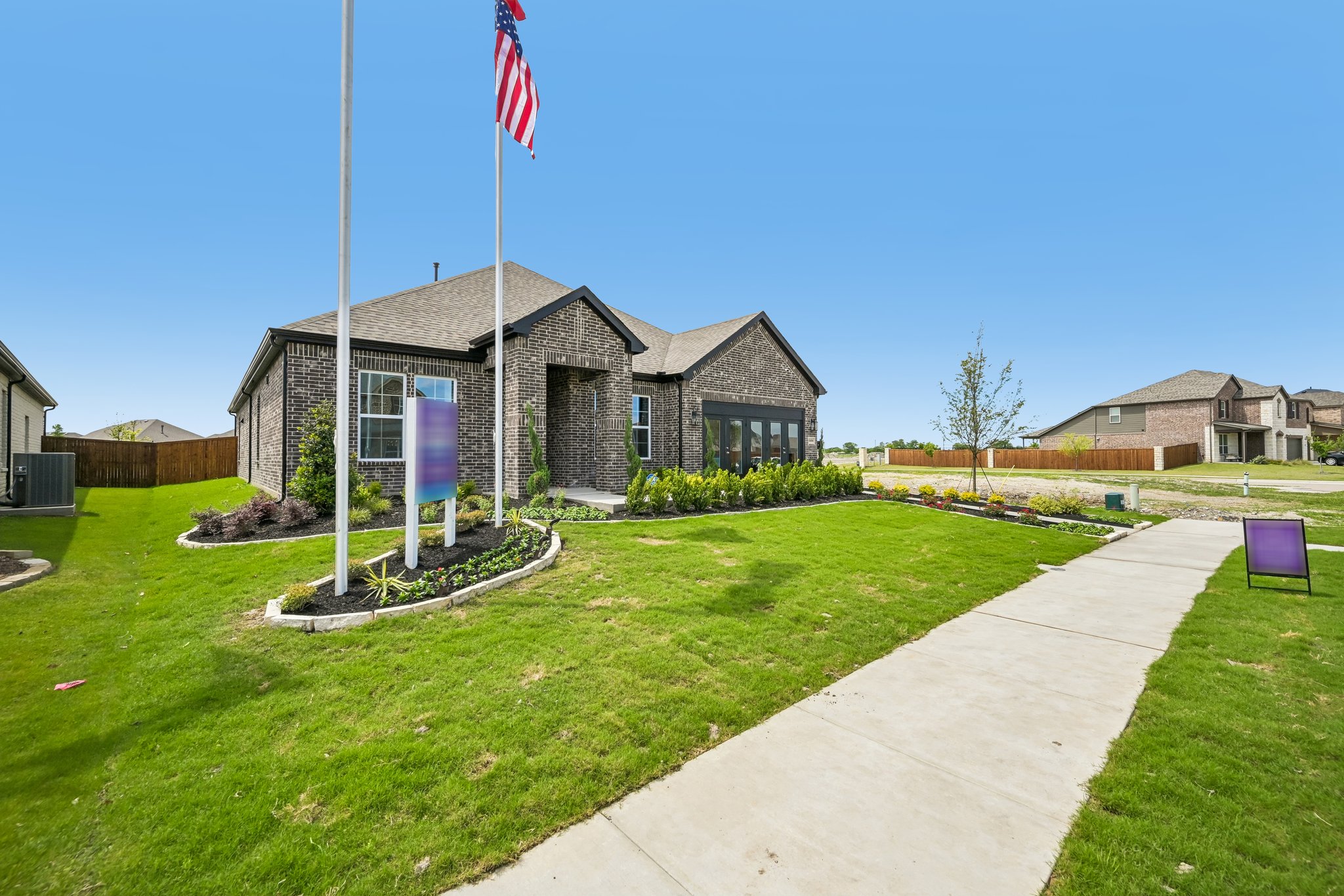 A sidewalk and a flagpole with a building in the background.