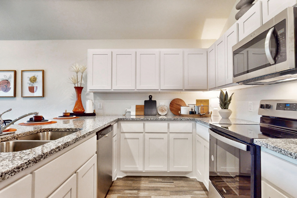 A kitchen with white cabinets.
