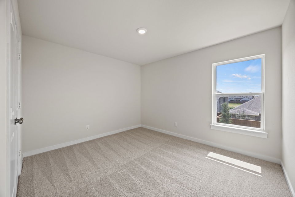 A room with a window and a carpet.