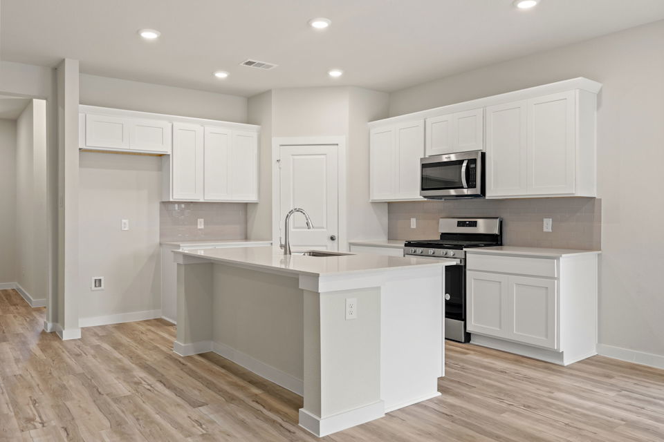 A kitchen with white cabinets.