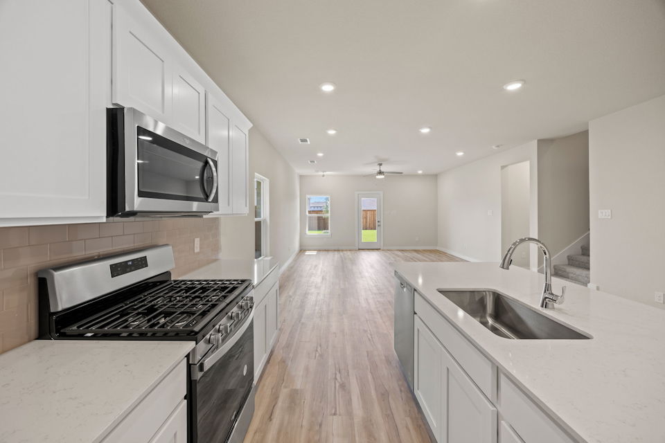A kitchen with white cabinets.
