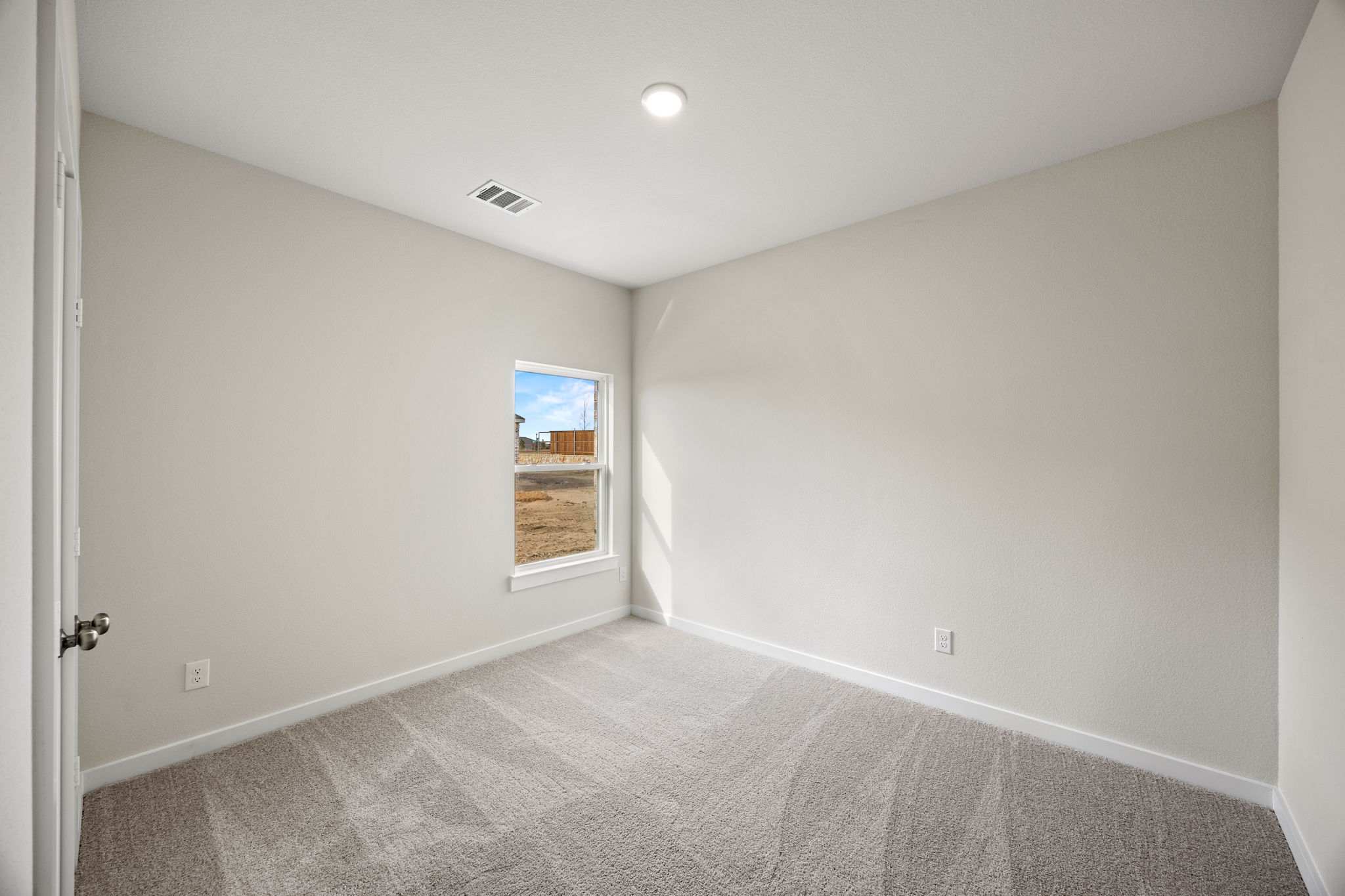 A room with a carpet and a window.