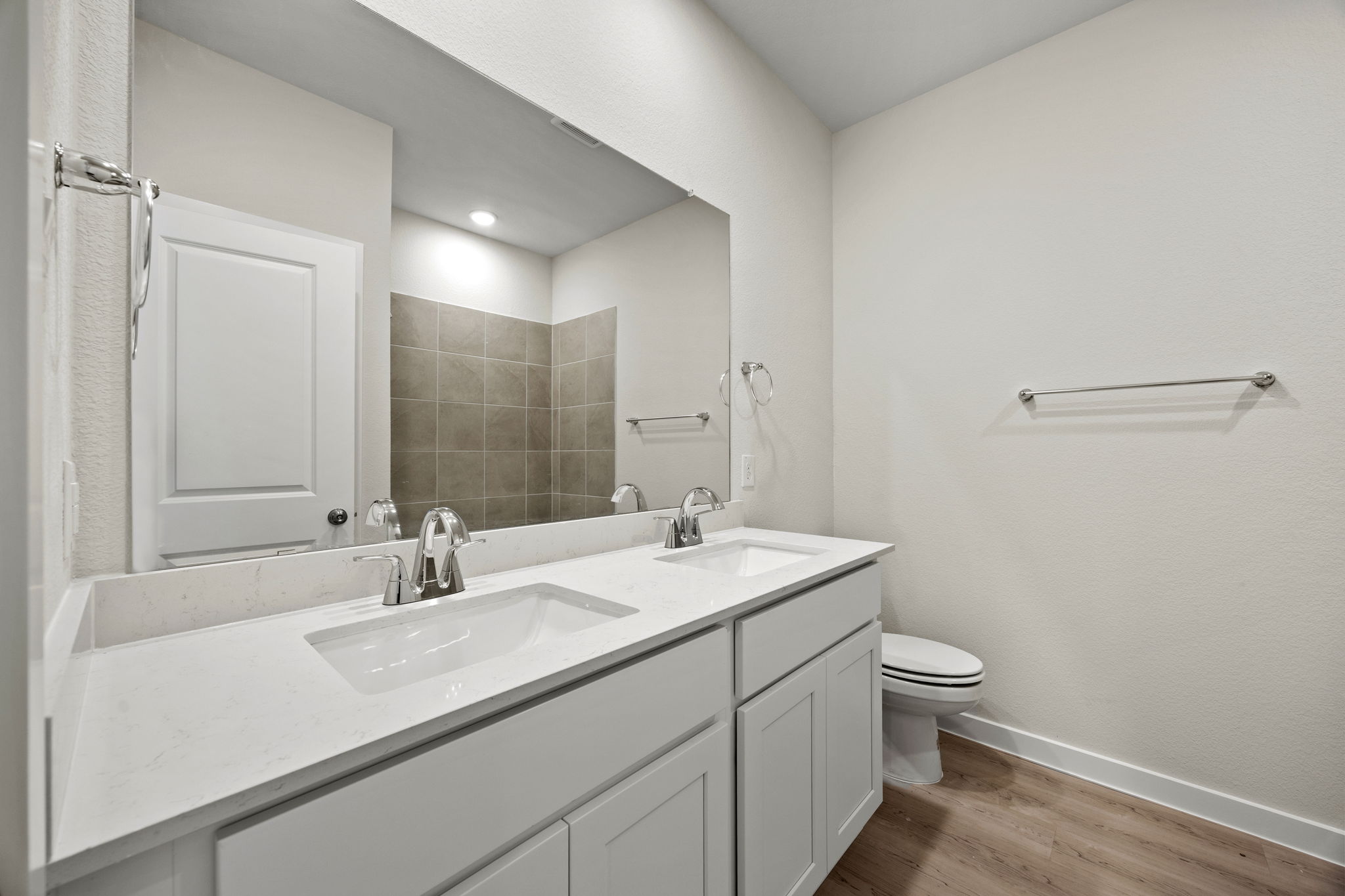 A bathroom with a large mirror.