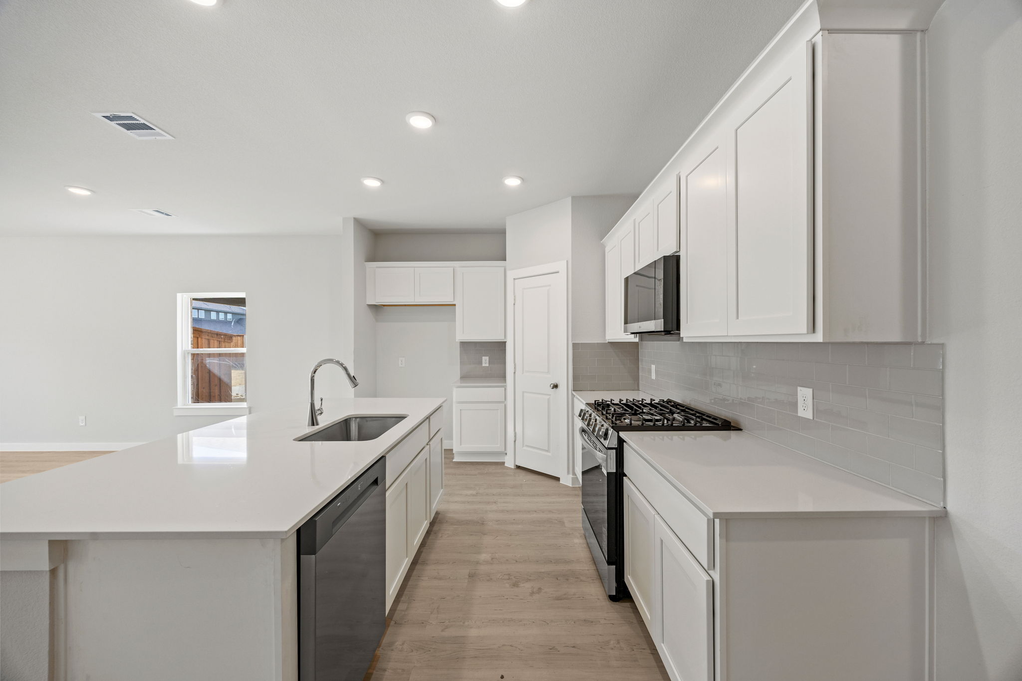 A kitchen with white cabinets.