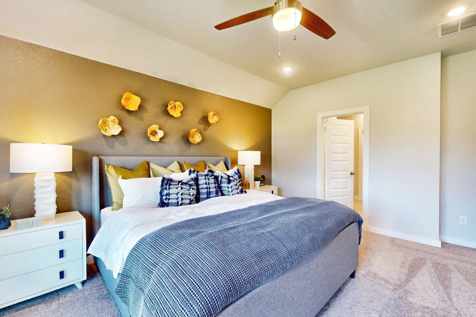 A bedroom with a bed and lamps.