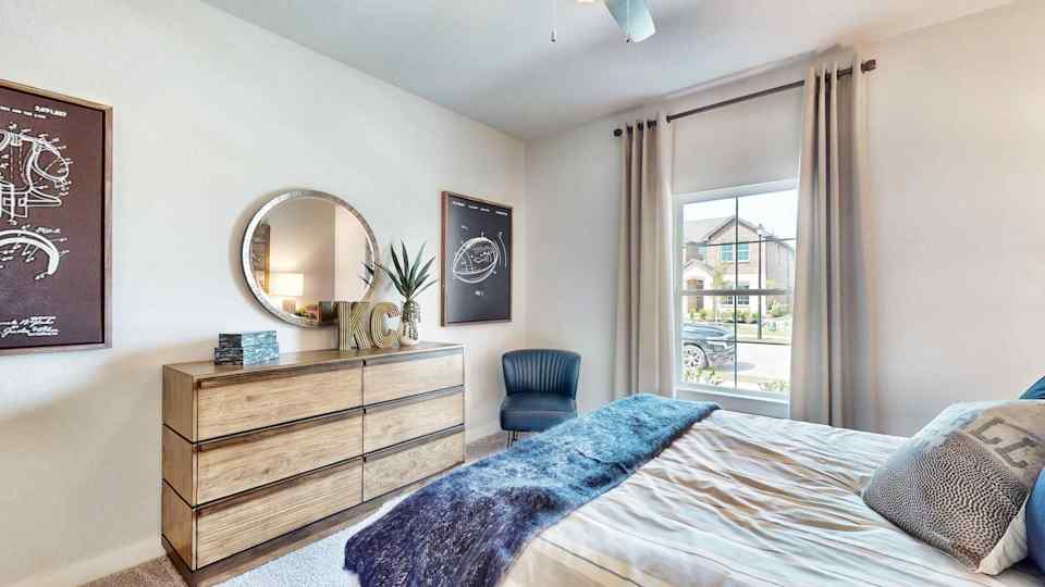 A bedroom with a bed and a chair.