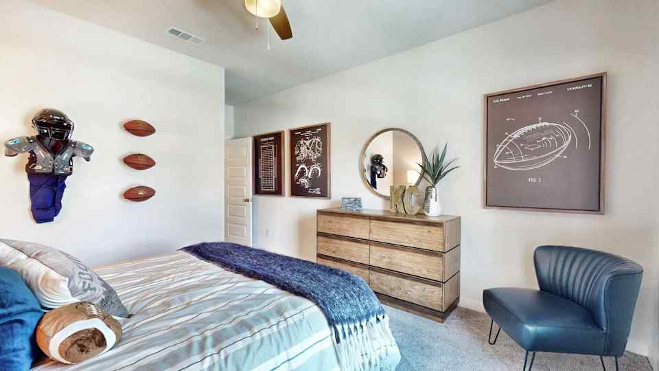 A bedroom with a bed and a chair.