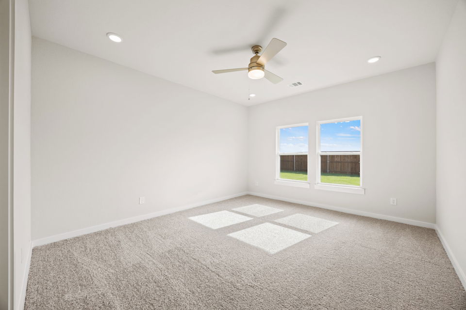 A room with a ceiling fan and a window.