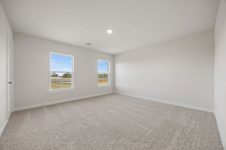 A room with a carpet and windows.