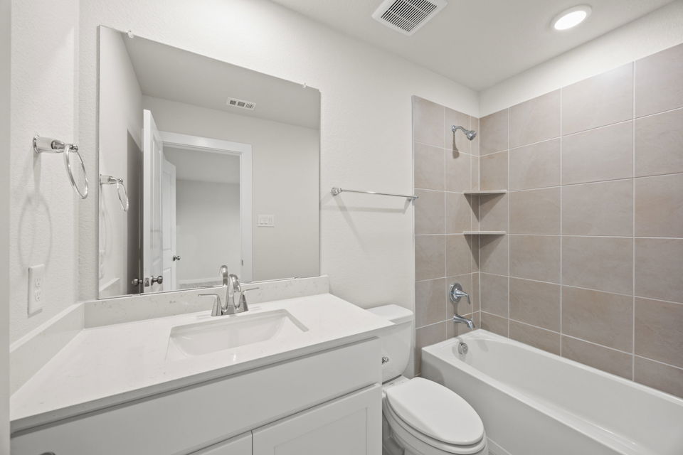 A bathroom with a tub sink and toilet.