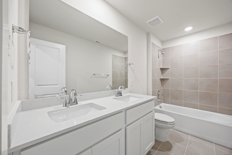 A bathroom with a tub sink and toilet.