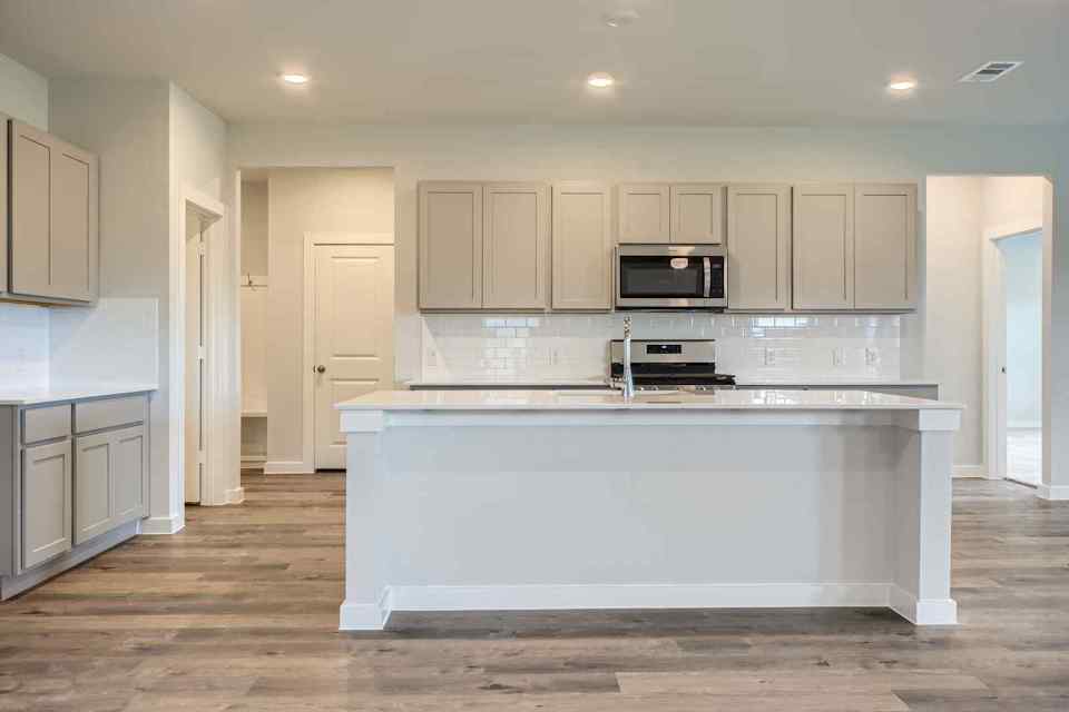 A kitchen with white cabinets.