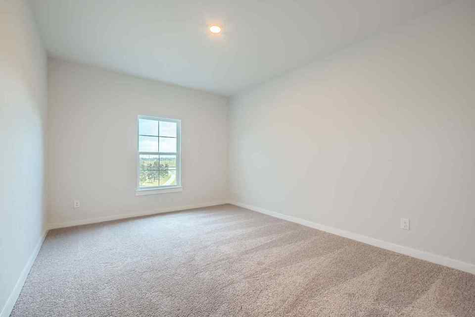 A room with a window and carpet.