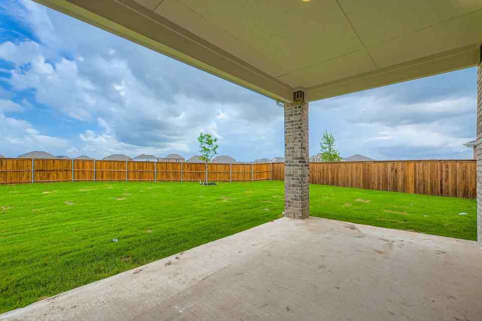 A fenced in field with a stone structure in the middle.