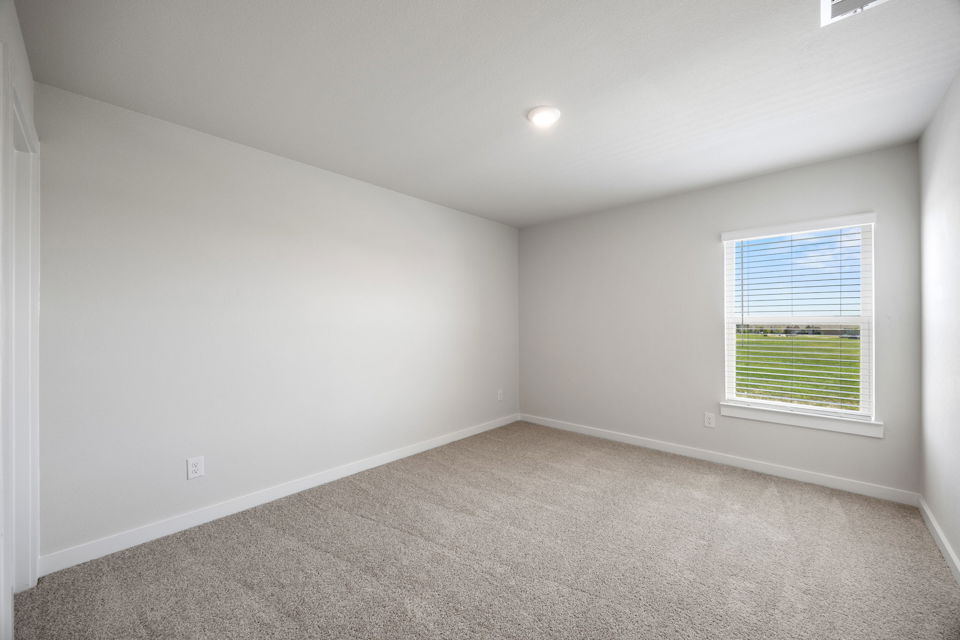 A room with a window and carpet.