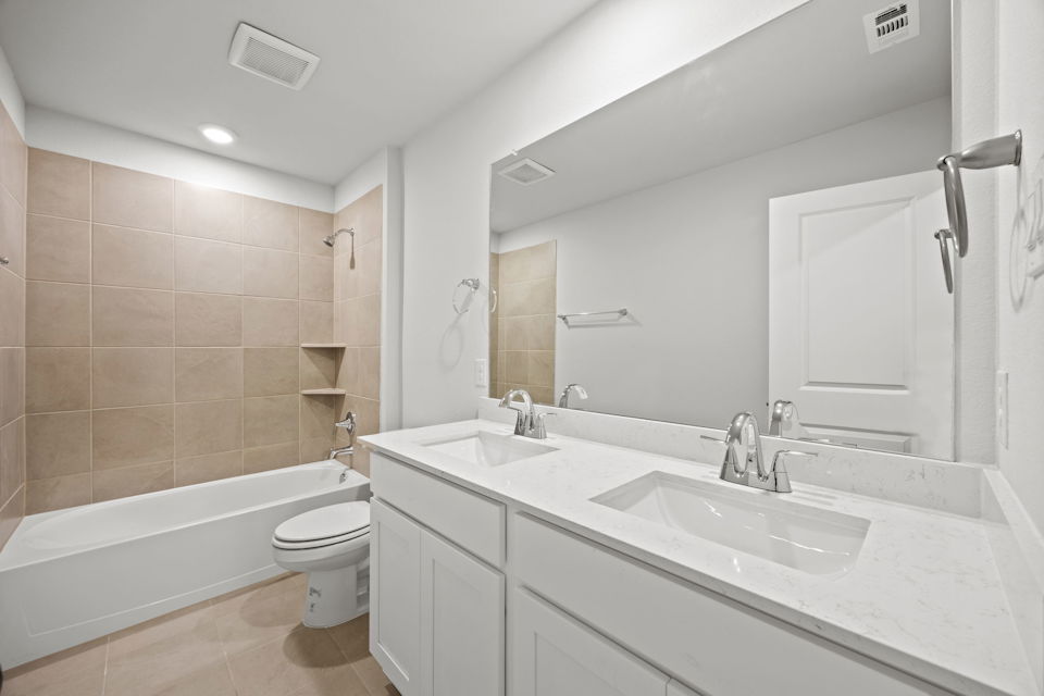 A bathroom with a tub sink and toilet.