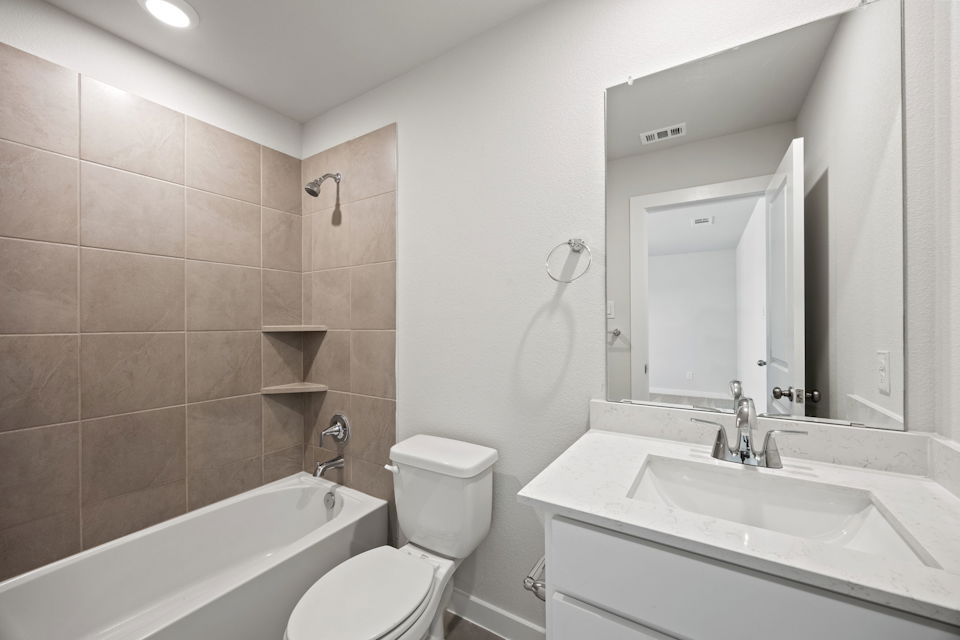 A bathroom with a tub sink and toilet.