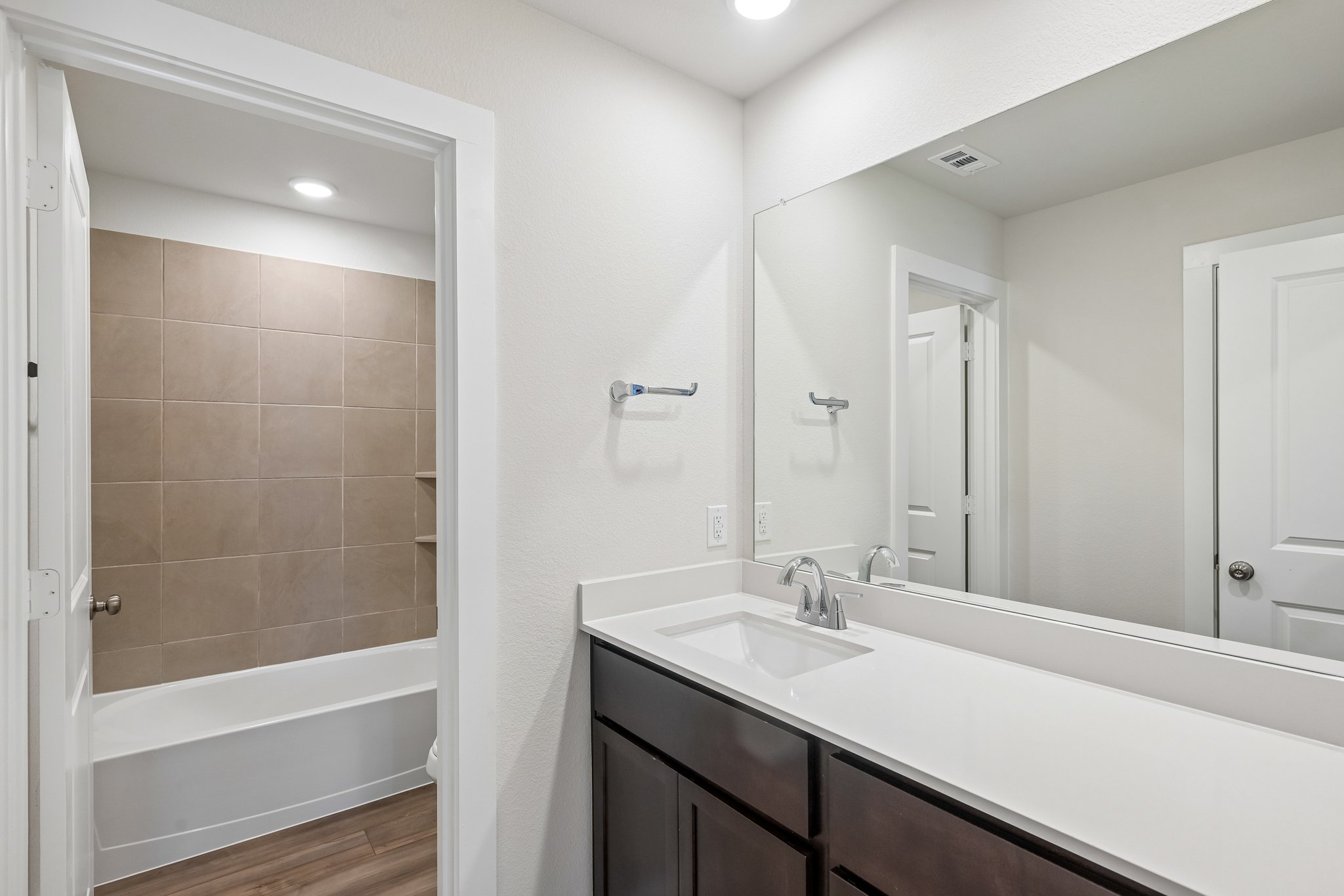 A bathroom with a tub sink and a shower.