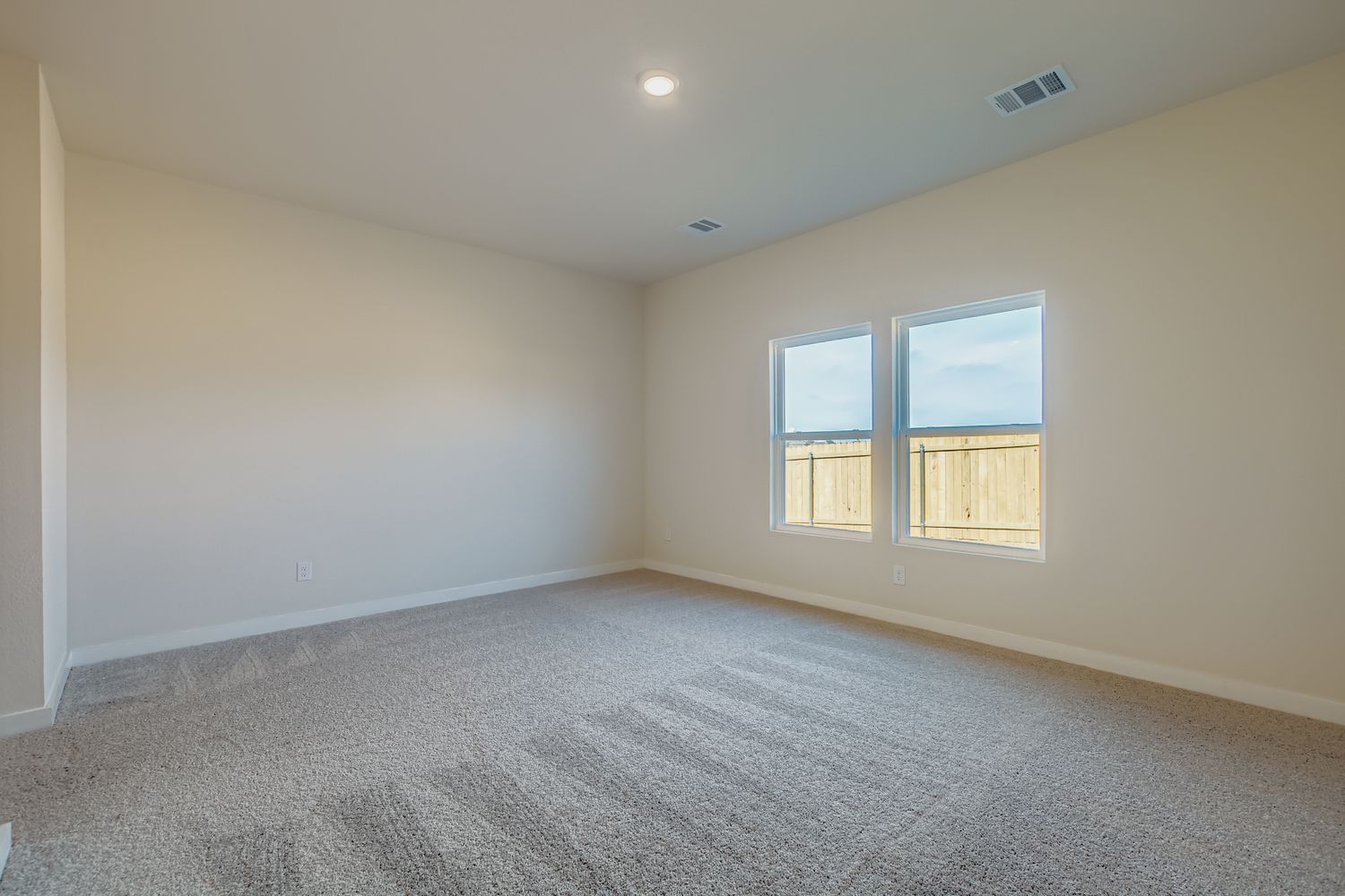 A room with a carpet and windows.