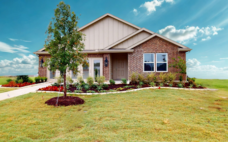 A house with a tree in the front yard.