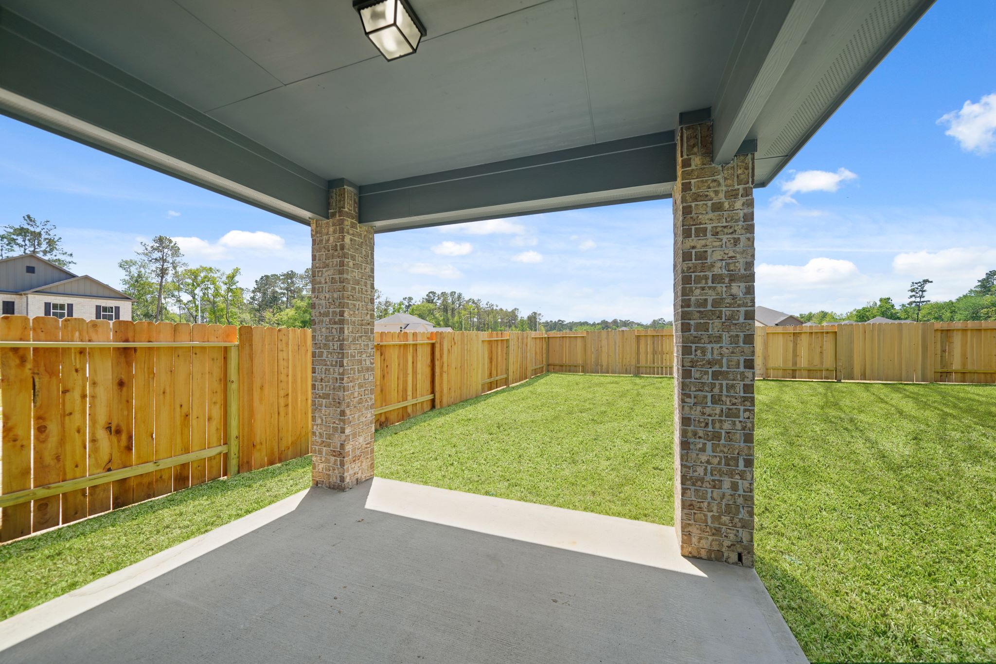 A fenced in yard with a wood gate and a wood gate.