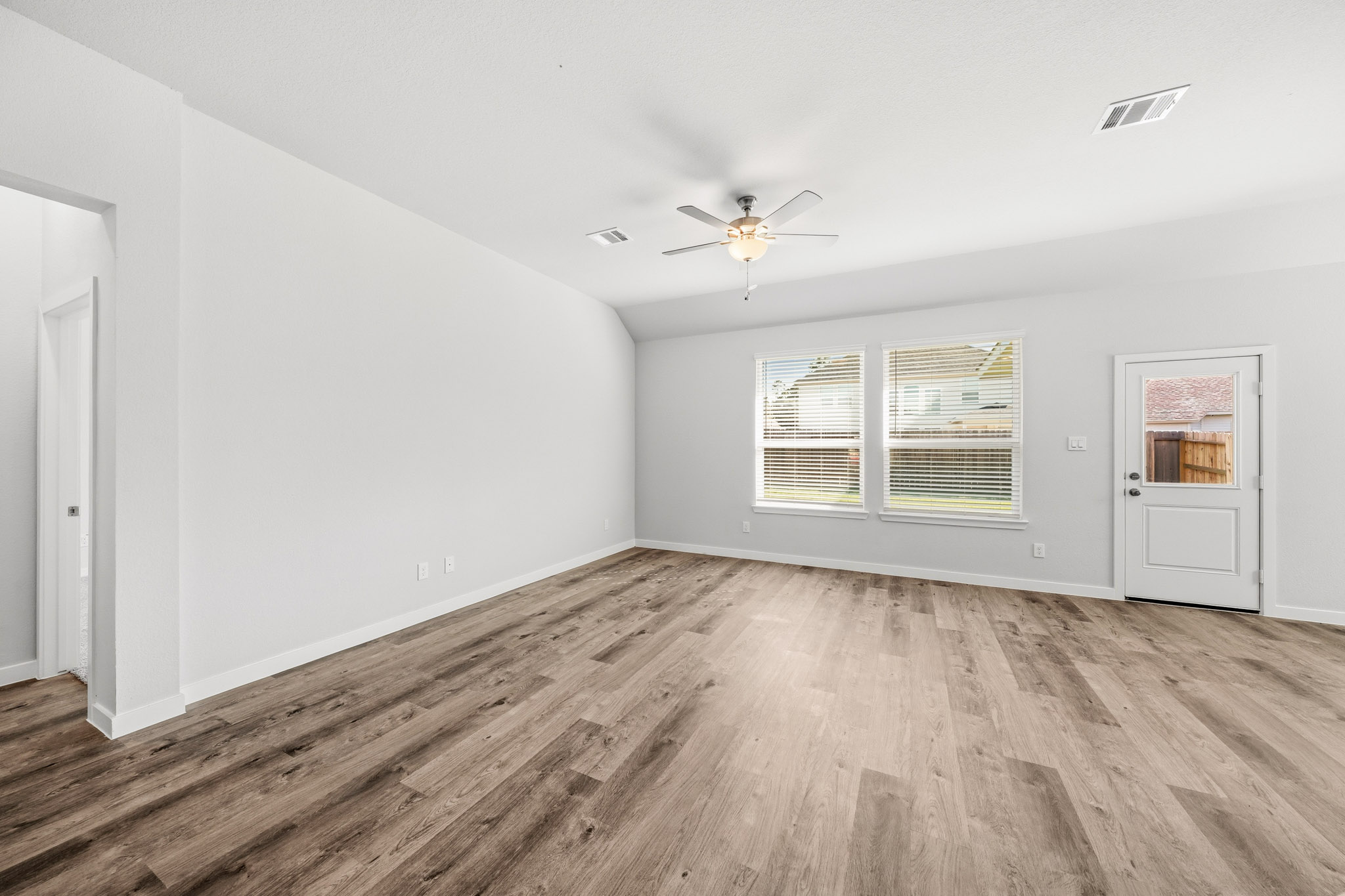 A room with a wood floor and a ceiling fan.