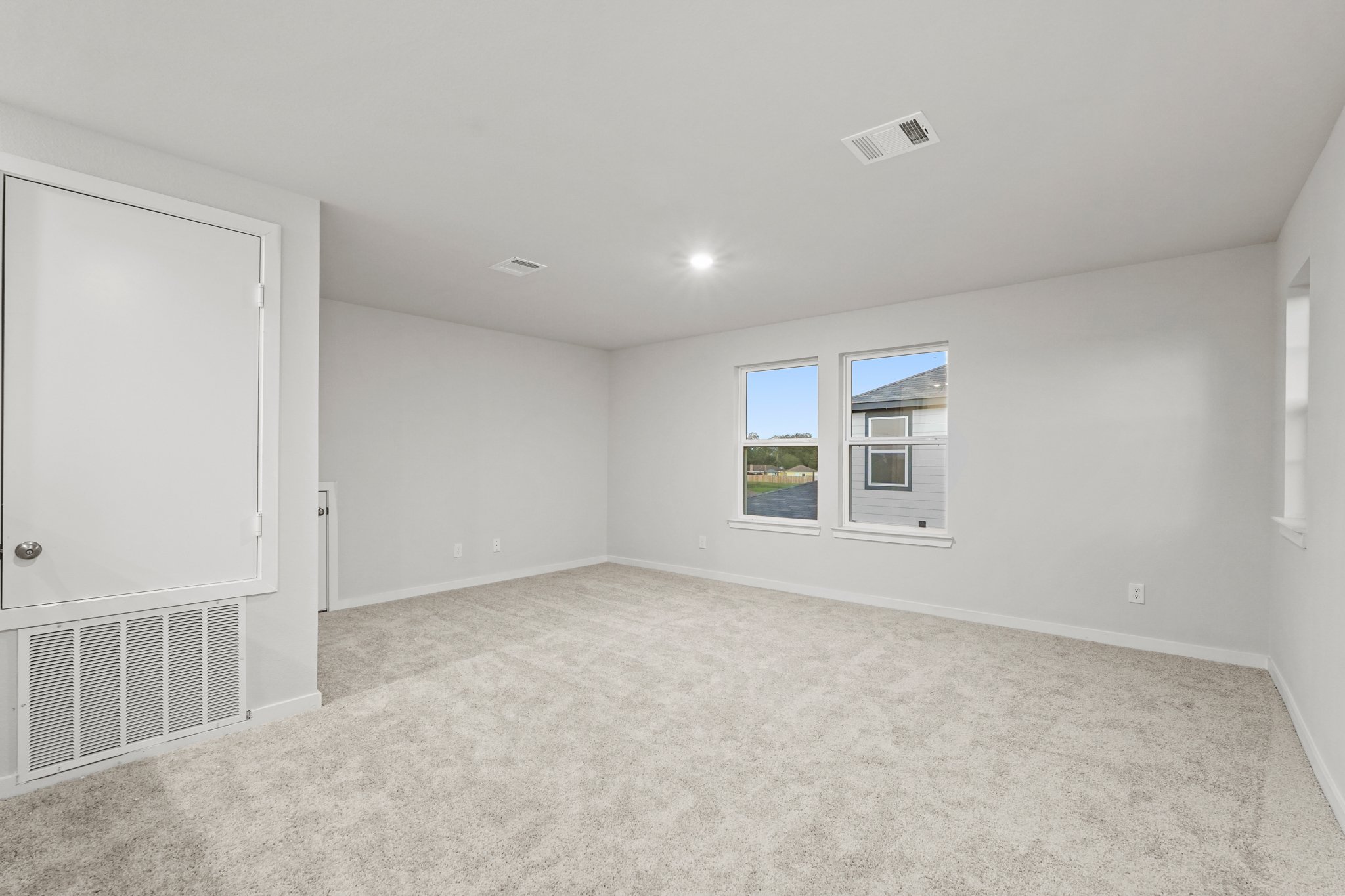 A room with a white door and windows.