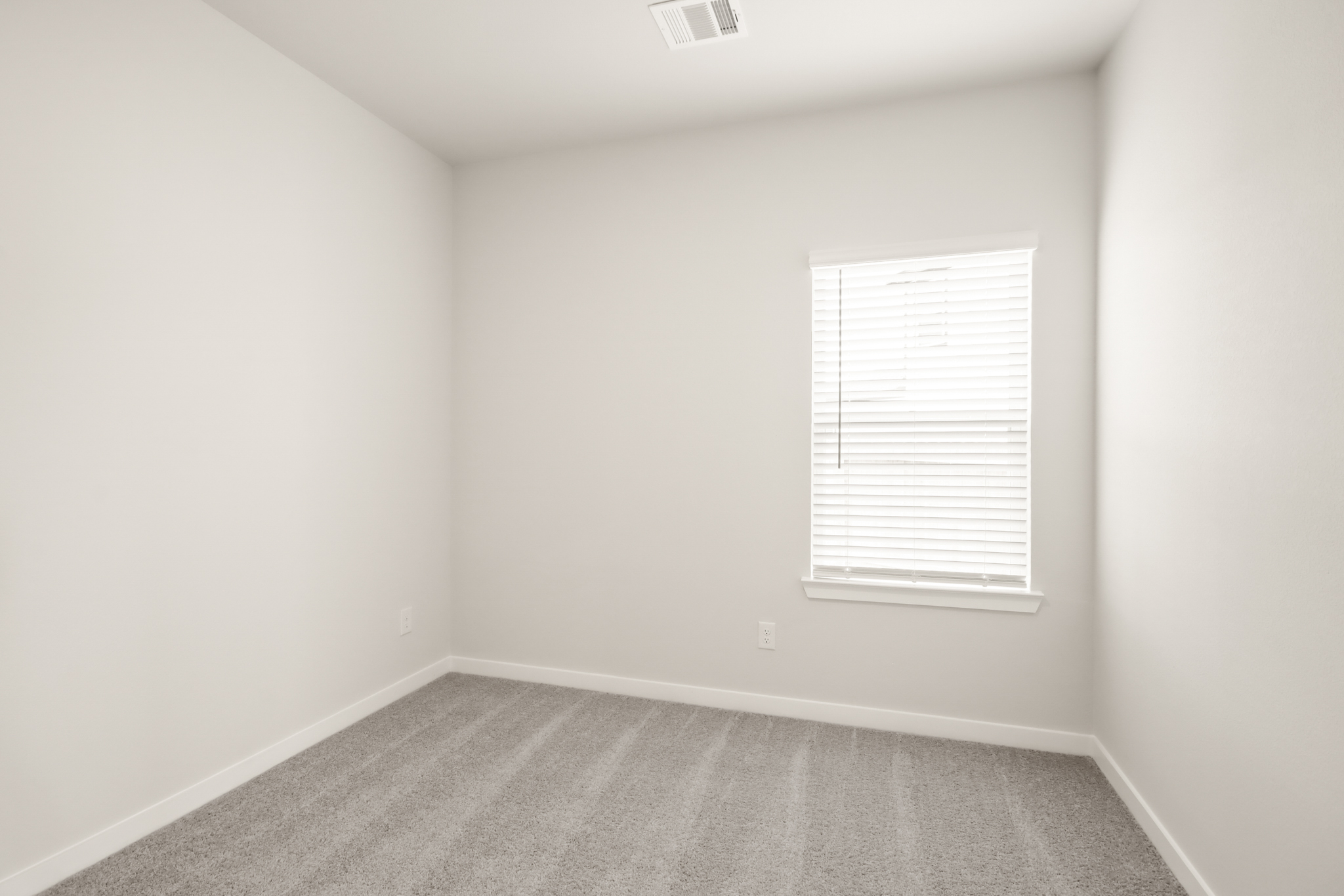 A room with a window and a carpet.