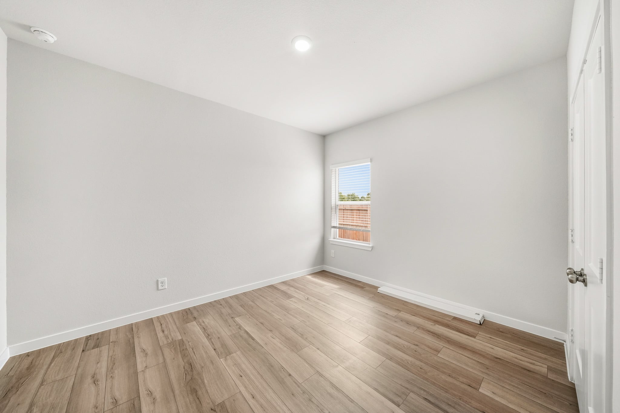 A room with a wood floor and a window.