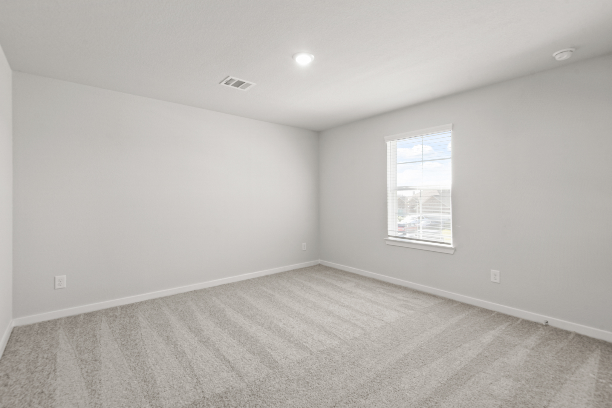 A room with a window and a carpet.