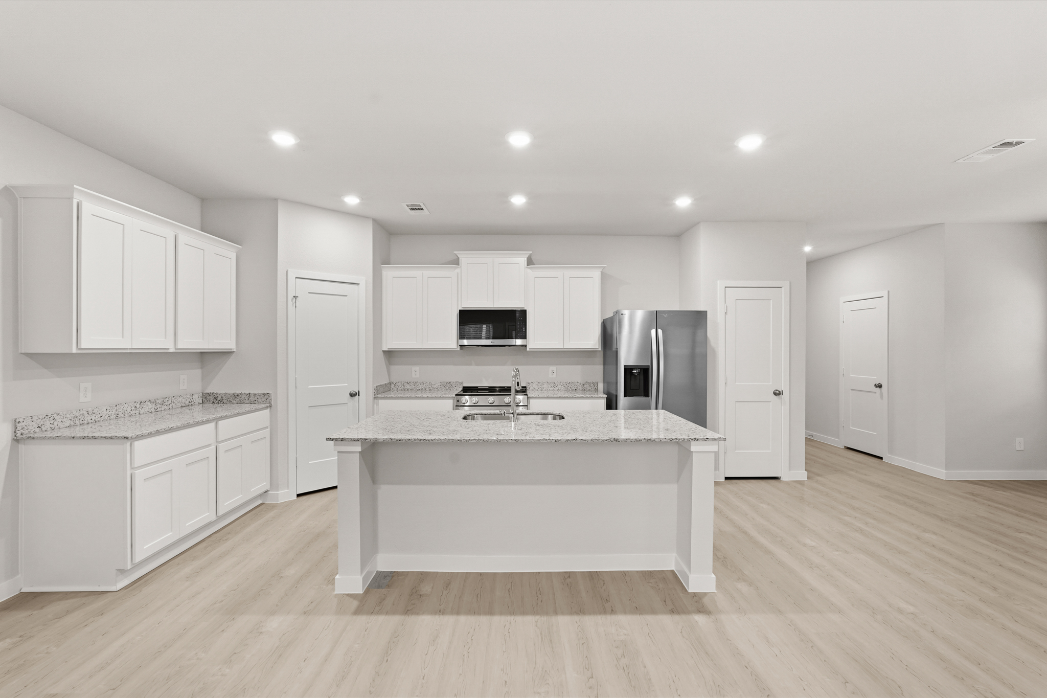 A kitchen with white cabinets.