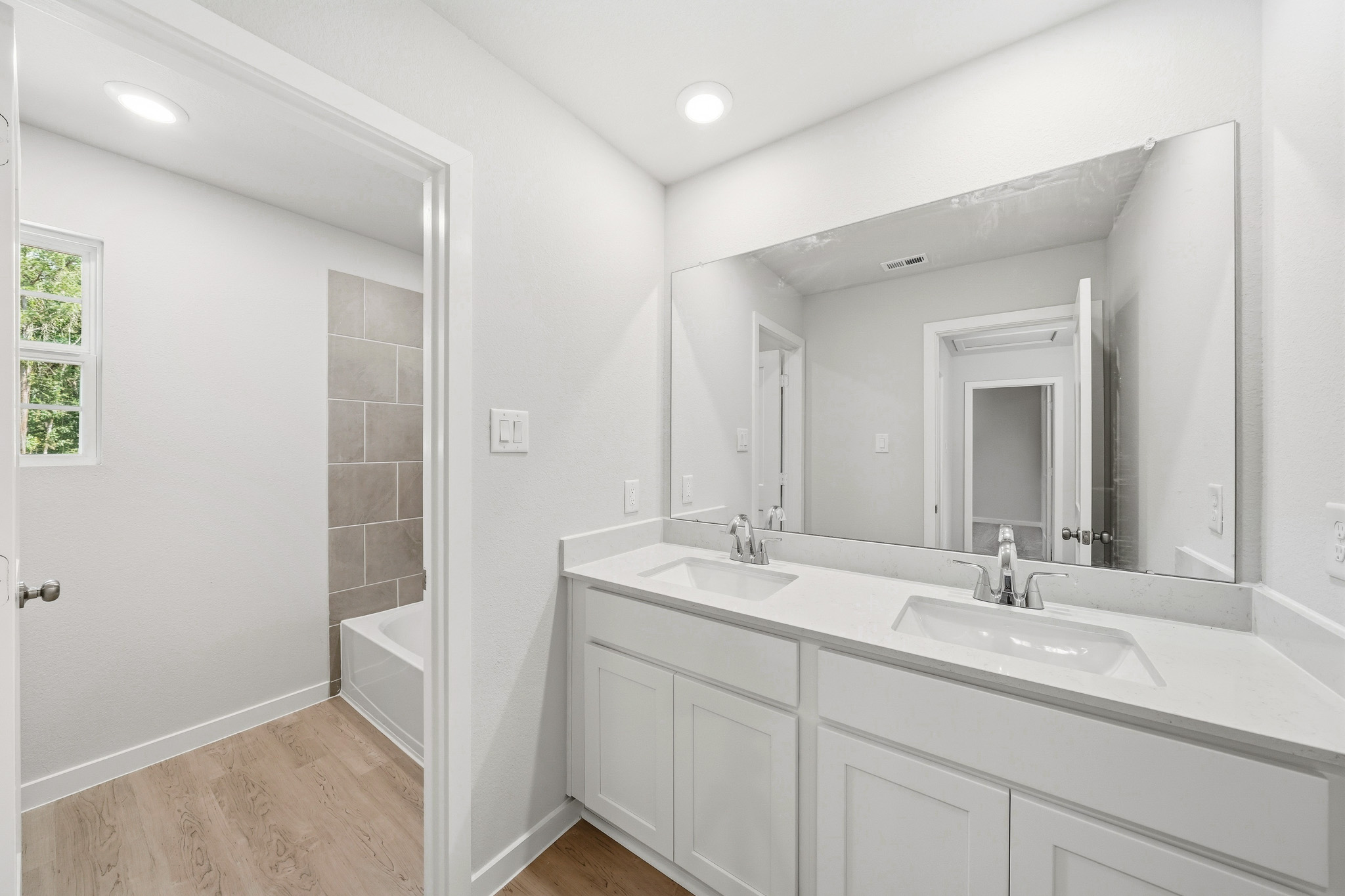 A bathroom with a large mirror.