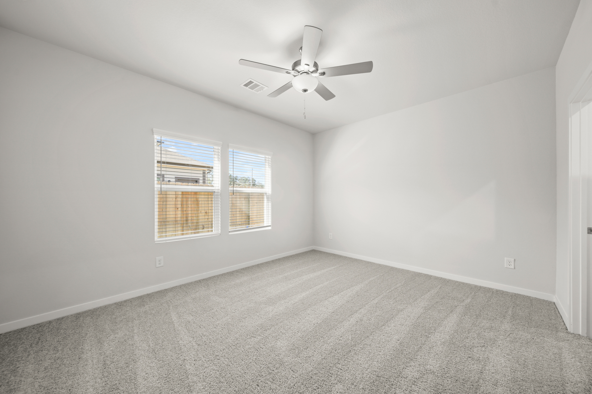 A room with a ceiling fan and a window.