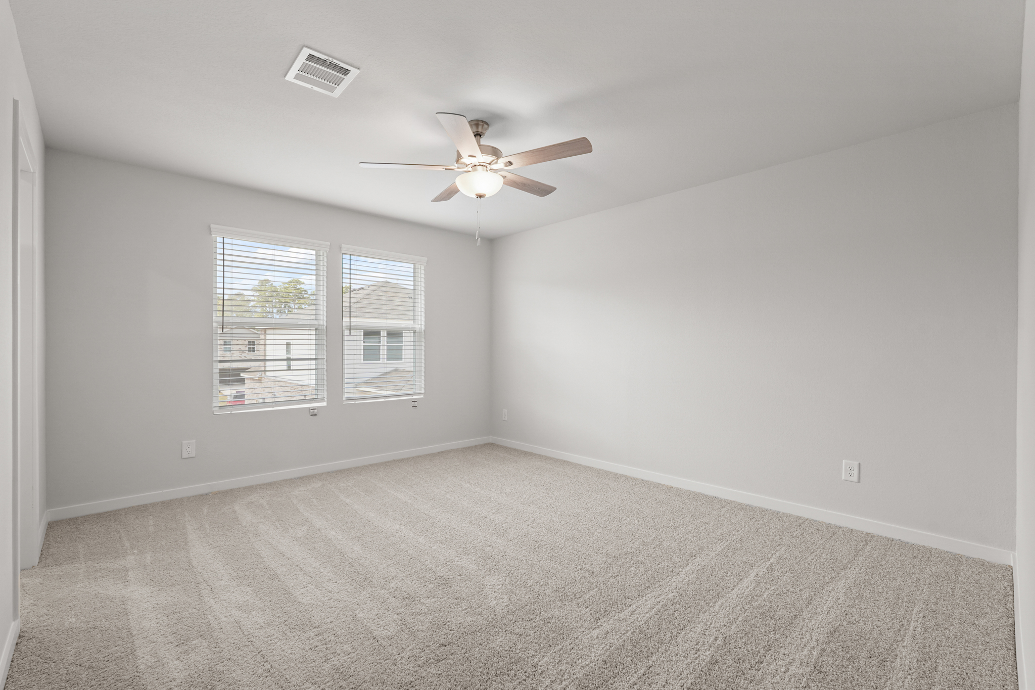 A room with a ceiling fan and a window.