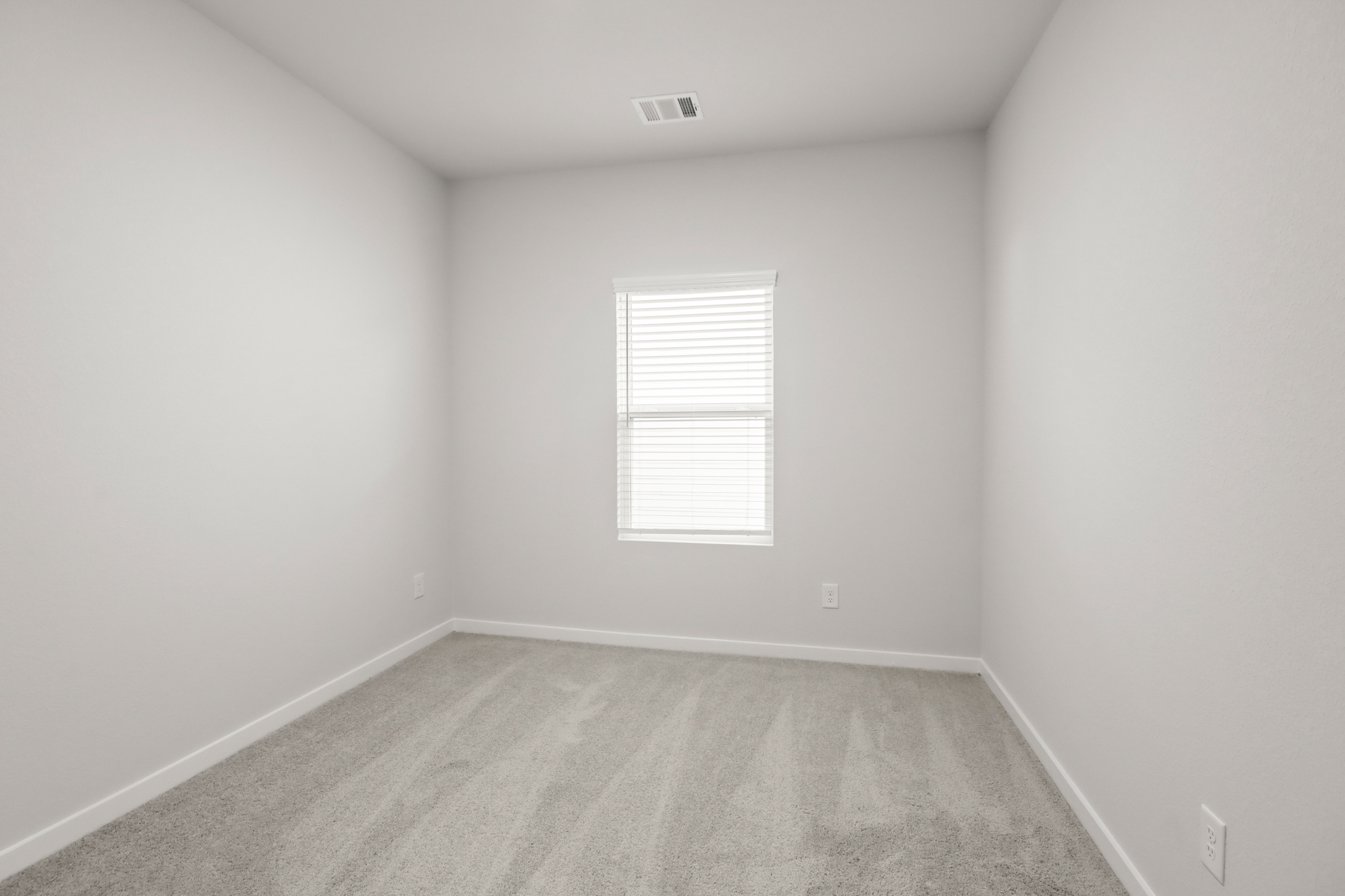 A room with a window and a carpet.