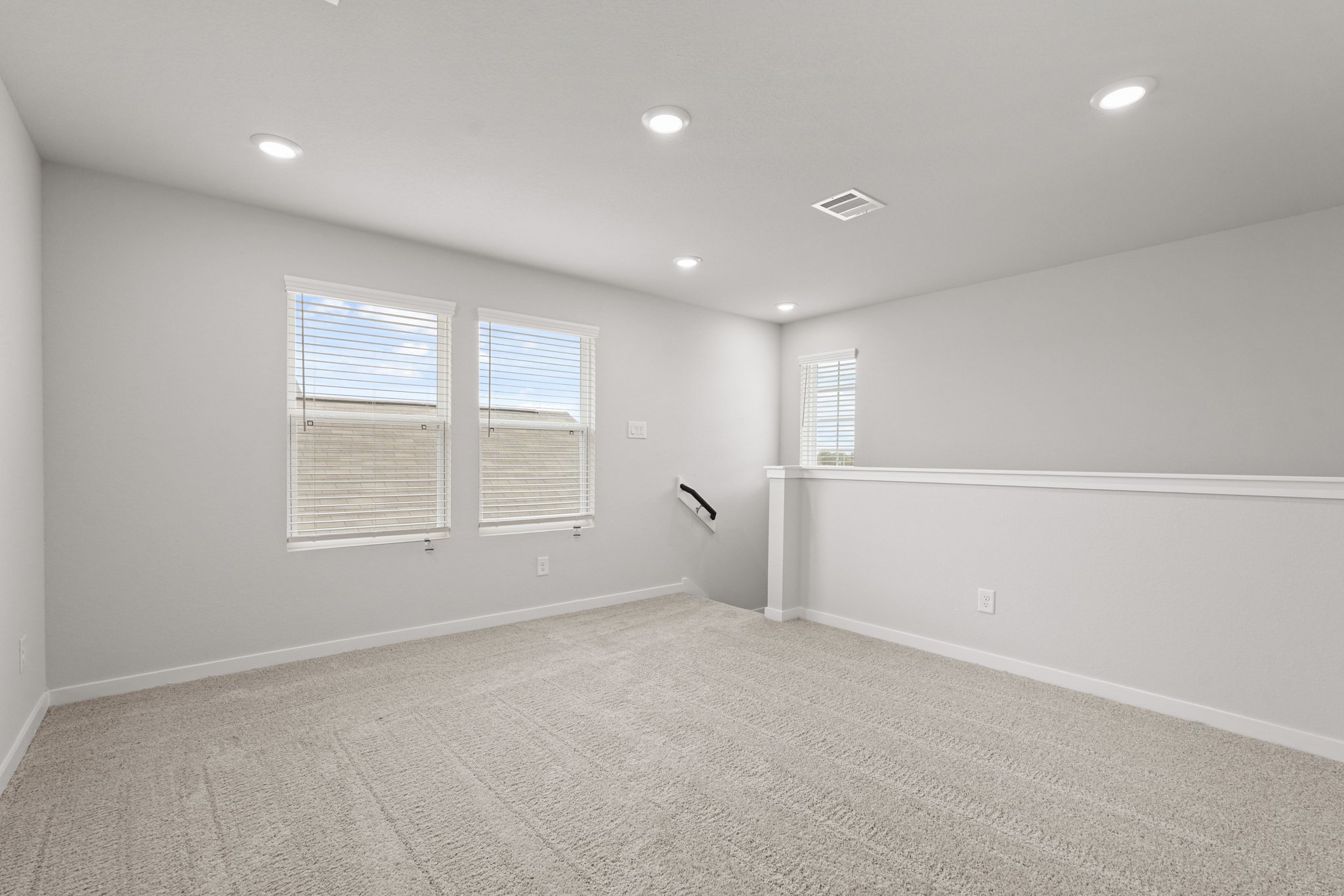 A room with a carpet and windows.