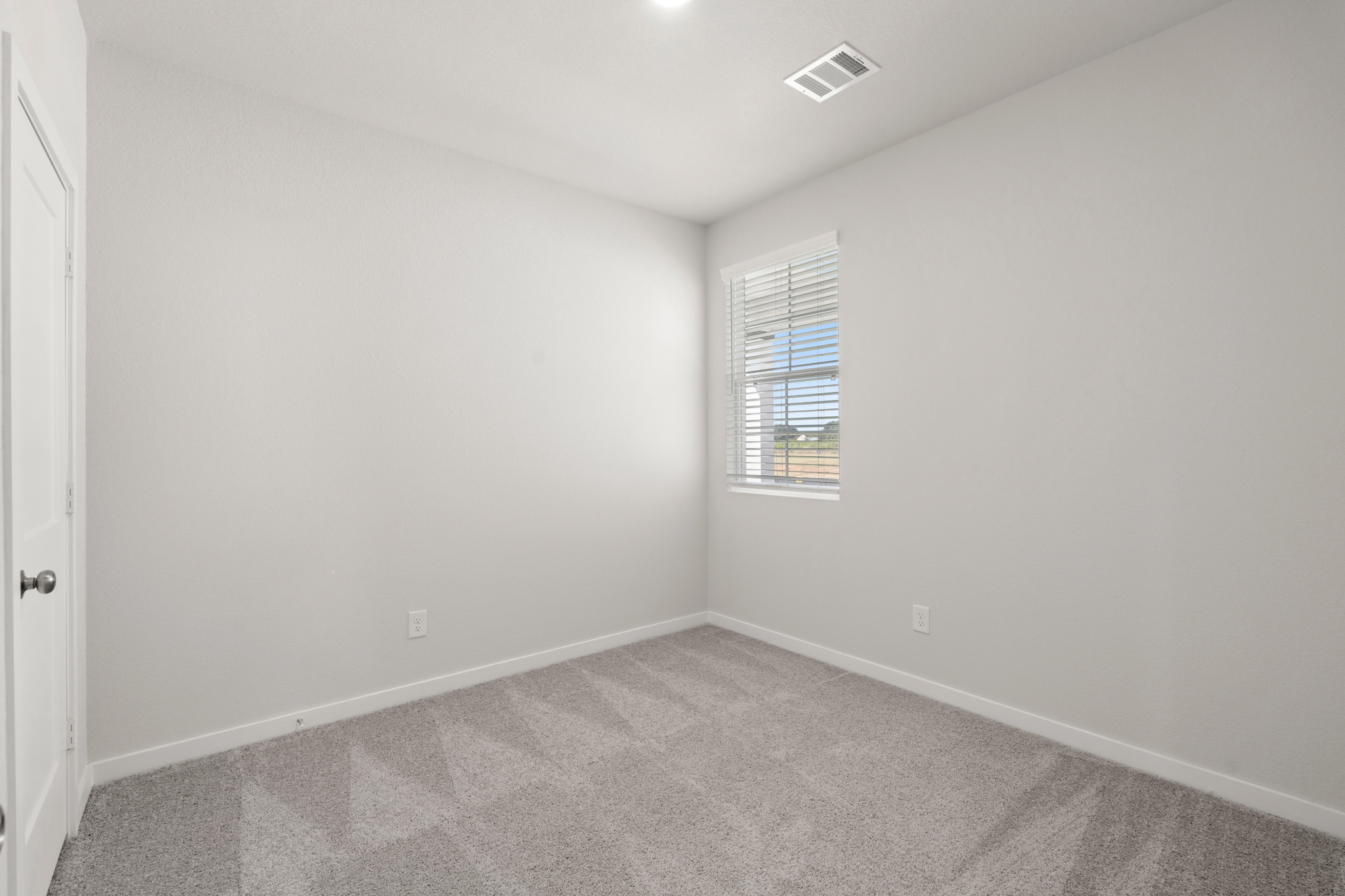 A room with a window and carpet.