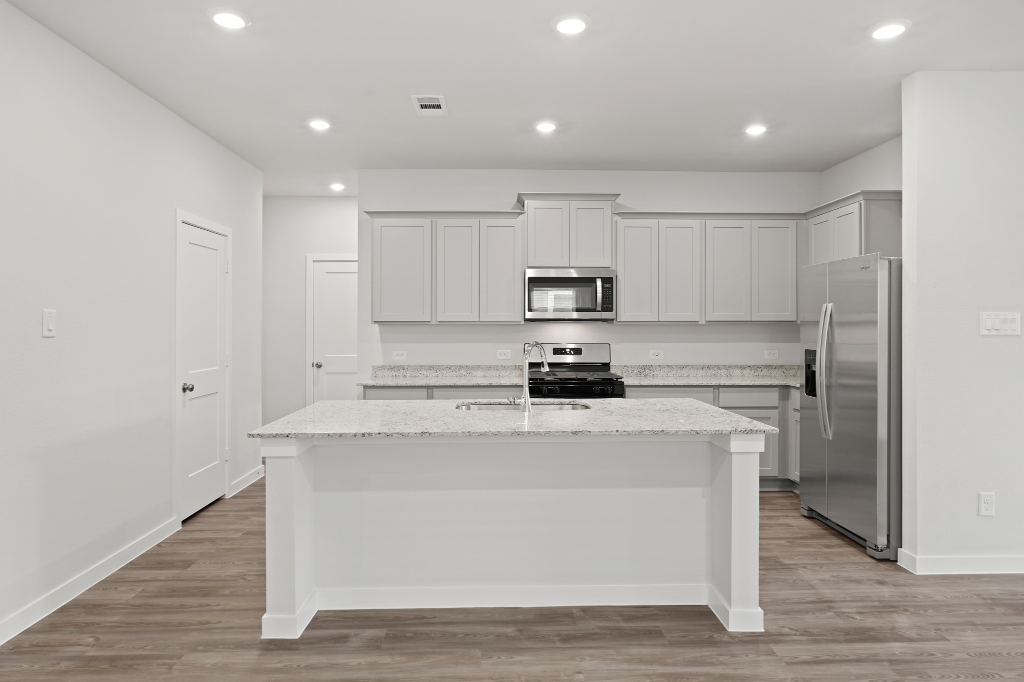 A kitchen with white cabinets.