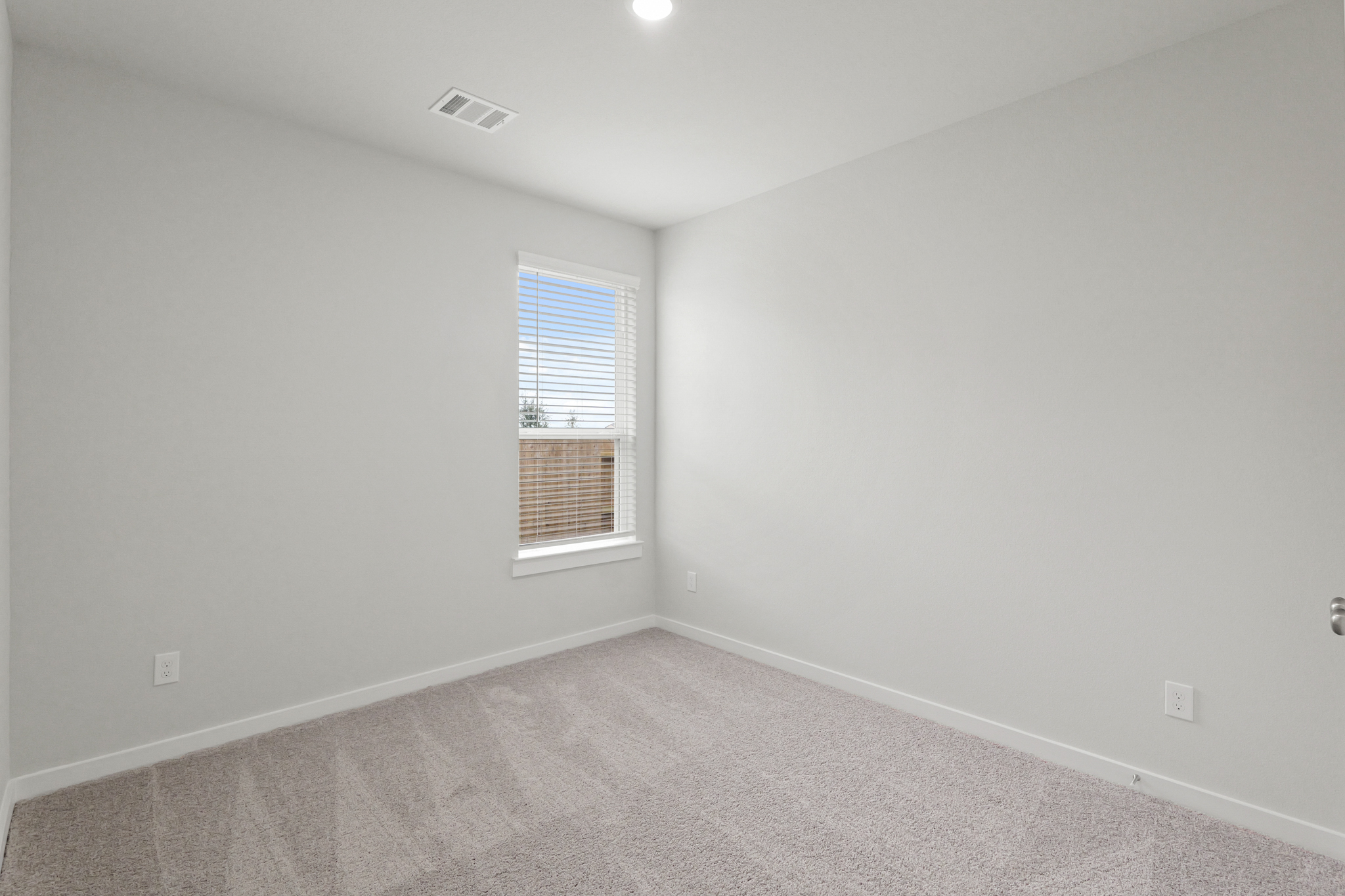 A room with a window and a carpet.