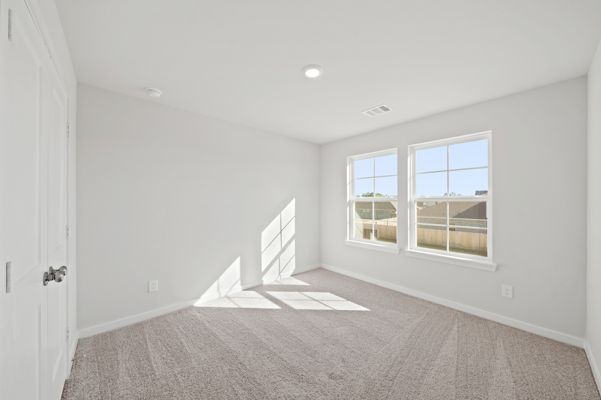 A room with a window and a rug.