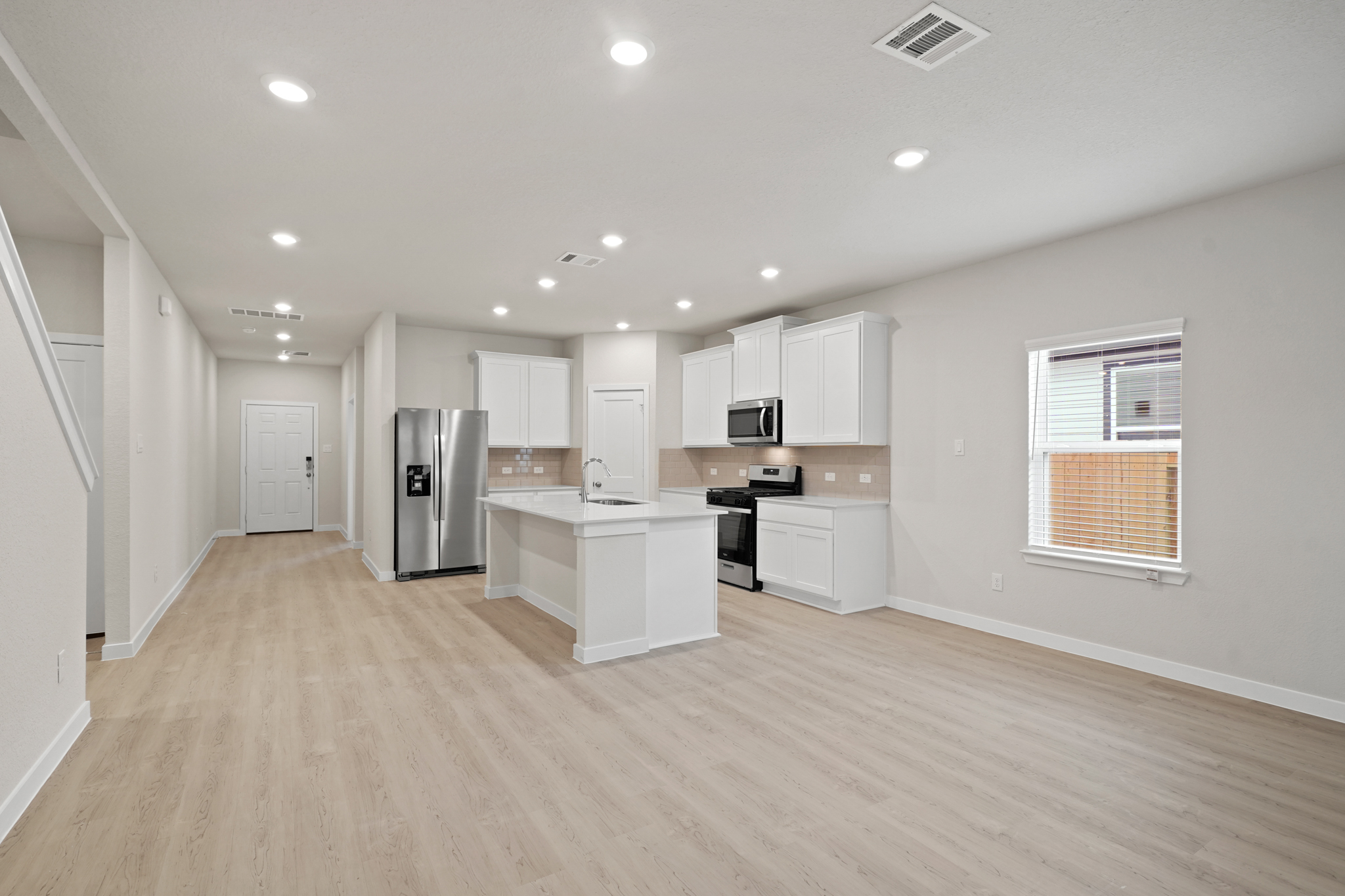 A kitchen with white cabinets.